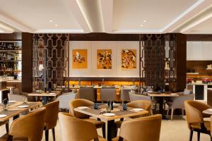 阿姆利则Fortune Ranjit Vihar, Amritsar- Member ITC's hotel group的一间带桌椅的餐厅和一间酒吧