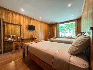 沙美岛Samed Garden Resort的一间卧室配有两张床、一张桌子和一台电视。