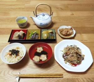 田边市民宿 和合 Minshuku WAGO的餐桌,餐桌上放着盘子和茶壶