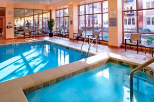雷丁利丁怀奥米辛万怡酒店的酒店大堂的游泳池,配有桌椅