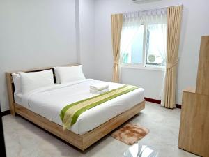 Ban Khlong WaPause Homestay的一间卧室配有一张带白色床单的床和一扇窗户。