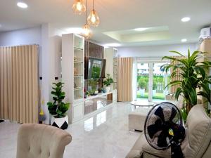 Ban Khlong WaPause Homestay的客厅配有白色家具和植物