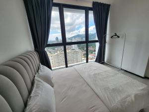 日落洞Executive Urban Suites - George Town @ Penang的卧室设有一张位于大窗户前的床铺。