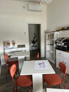 博洛尼亚B&B La Fenice的厨房配有橙色椅子和白色桌子