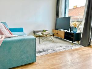 布达佩斯Central Apartment Budapest ~ Roof Terrace/AC/Indoor parking的客厅配有蓝色的沙发和电视