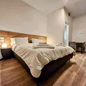 博洛尼亚b&b marconi 49的一间卧室配有一张大床和木制床头板