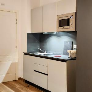 博洛尼亚b&b marconi 49的厨房配有水槽和微波炉