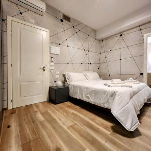 博洛尼亚b&b marconi 49的卧室配有一张白色的大床,铺有木地板