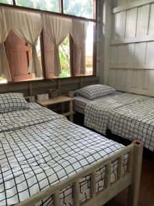 Kampong HuaibūYor Song Hostel Pai的带2扇窗户的客房内的2张床