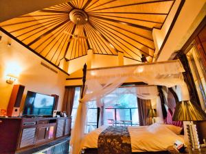 大分SKY PARADISE スカイパラダイス　ラクエン的一间卧室配有一张天蓬床和一台电视机