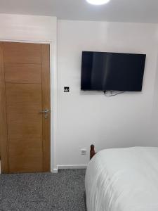伦敦7 Venus Road (Room 7)的卧室配有一张床和壁挂式平面电视。