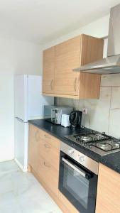伦敦7 Venus Road (Room 7)的厨房配有木制橱柜和炉灶烤箱。