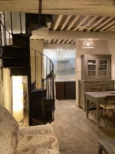 索尔格河畔利勒Maison d'hôtes Campagne-Baudeloup的一间带楼梯的客厅和一间厨房