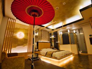 大分SKY PARADISE スカイパラダイス　ラクエン的卧室配有一张大红伞,位于床上