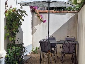 卡尔卡松Les Gîtes de Nathalie: Corneille et Rivals的庭院的太阳伞下桌椅