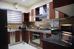 开罗Luxurious apartment - New Cairo的厨房配有木制橱柜和不锈钢用具