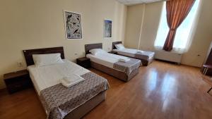 鲁塞Hostel CANTO的客房设有两张床和大窗户。