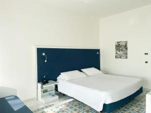 卡普里里贾纳克里斯蒂娜酒店的一间卧室配有一张大床和蓝色床头板