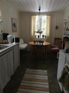 ForshagaLillemyrsgården的厨房配有桌子和桌椅