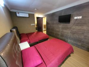 刁曼岛Tamara Guest House的酒店客房设有两张床和一台平面电视。
