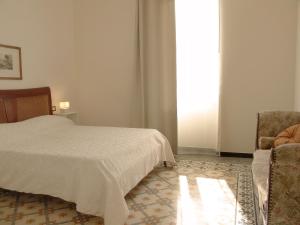 莱万托Residenza Cavour - Appartamento AGAVE的卧室配有床、椅子和窗户。