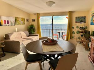 贾迪尼-纳克索斯LA MANSARDA的客厅配有桌子,享有海景