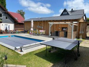 鲁拉Waldfrieden Ferienhaus mit SAUNA的房屋后院的乒乓球桌