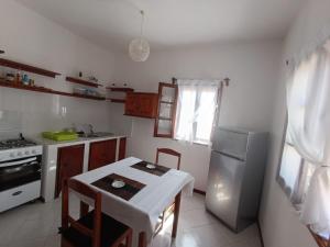 萨尔雷Vilas na areia aparthotel的一间带桌子和冰箱的小厨房