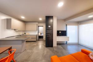 马格拉Stadler Loft的开放式厨房和带橙色椅子的客厅
