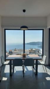 贝西奇Modern Top Floor Sea View 3BR with Pools, Spa & Fitness的一间带桌椅和大窗户的用餐室