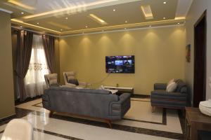 开罗Luxurious apartment - New Cairo的客厅配有沙发和墙上的电视