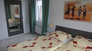 乌埃克尔明德FEWO-bis-2-Pers-inmitten-den-Yachthafens-Ueckermuende-Stettiner-Haff-Ostsee的一间卧室,床上有红色的鲜花