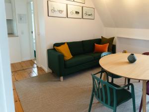 哥本哈根Quiet apartment的客厅配有绿色沙发和桌子