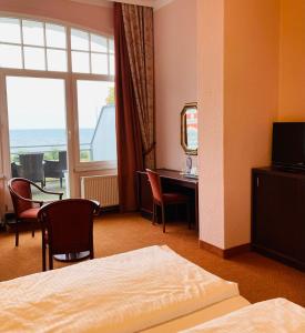 赛巴特班森哲迈尼尔酒店的配有一张床、一张书桌和一扇窗户的酒店客房