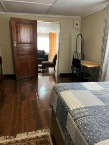 卢萨卡Furnished self catering cottage的一间卧室配有一张床、一张桌子和一把椅子