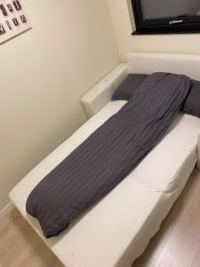 奥斯陆Rom # 2 Appartmenthotell Oslo Adress Isabels vei 16的卧室配有带灰色棉被的床