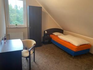 KosobudzHotel Kos的卧室配有1张床、1张桌子和1把椅子