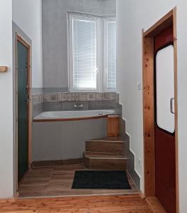 SzobToronySzoba的带浴缸的浴室和带窗户的楼梯