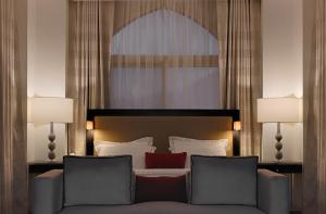 麦加Al Joud Boutique Hotel, Makkah的一间卧室配有一张沙发床和两盏灯。
