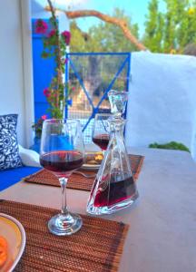 阿彻奇洛斯Aegean Serenity - Sea View Retreat的坐在桌子上的一杯红葡萄酒