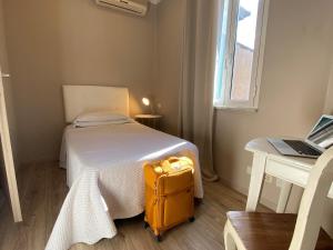 罗马欧瑞狄荣马酒店的坐在房间床边的黄色手提箱