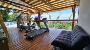 圣玛丽海伦娜别墅小木屋的客厅设有带沙发和跑步机的健身房