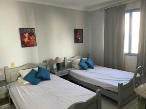 沙姆沙伊赫Ras Katy Sunset Views的一间卧室配有两张带蓝色枕头的床