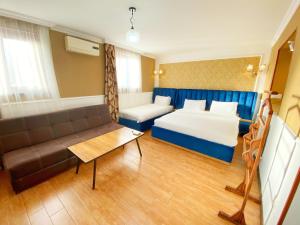 库塔伊西Hotel Orange Kutaisi的酒店客房,配有床和沙发