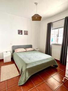 AlpedrizCasa Mourato的一间卧室配有一张带绿色棉被的床