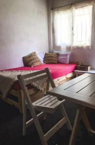 ConcordiaCampo Verde III的一间卧室配有一张带红色床垫的床和两把椅子