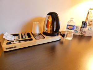 里摩日Hotel Be Guest Limoges Sud - Complexe BG的餐桌上的咖啡壶和一瓶水