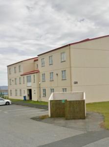 Ytri-NjarðvíkG-1215 apartment的停车场前方的大建筑