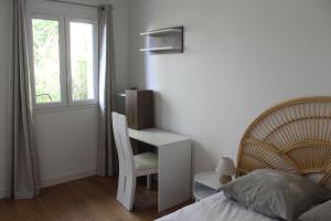 勒韦西内Au Tour Des Bois的一间卧室配有书桌、一张床和一把椅子