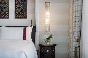 亚喀巴Al Manara, a Luxury Collection Hotel, Aqaba的一间卧室配有一张床和一个带台灯的边桌
